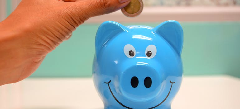 person putting a coin in a piggy bank.